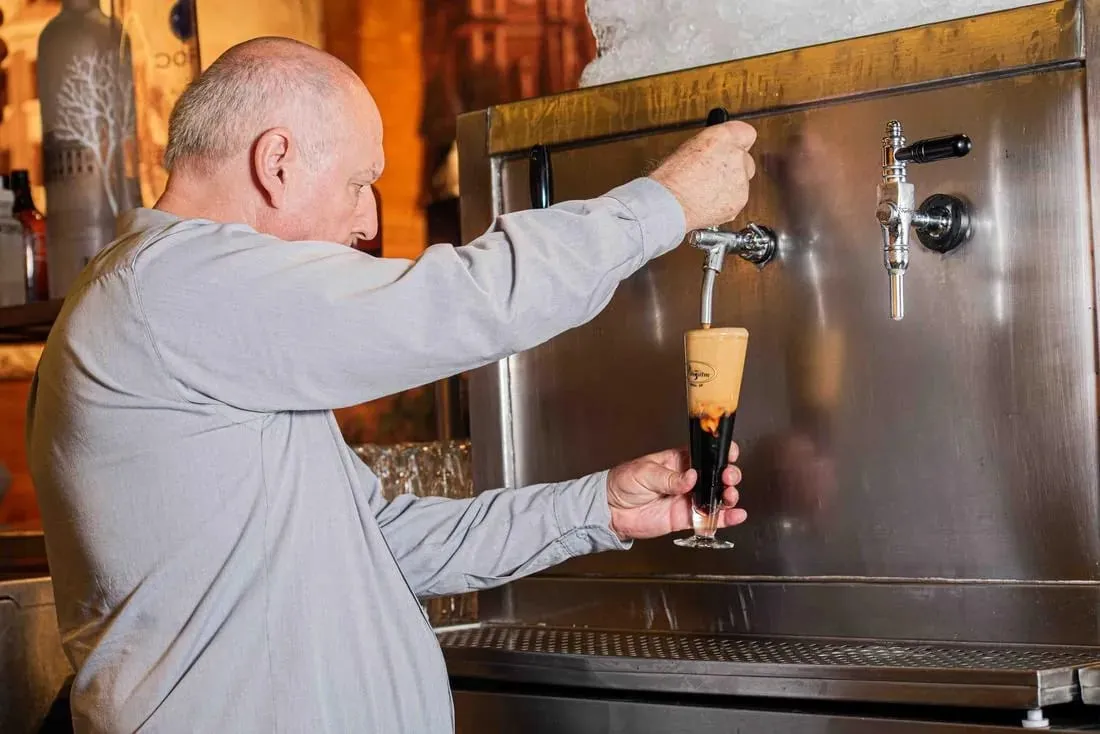 Chopp escuro sendo tirado com cuidado na torneira